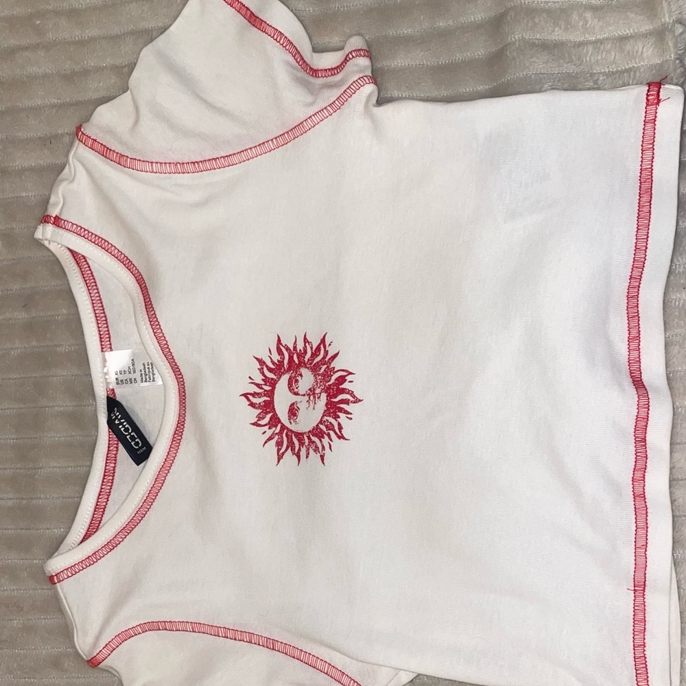 White top with sun and red stitching